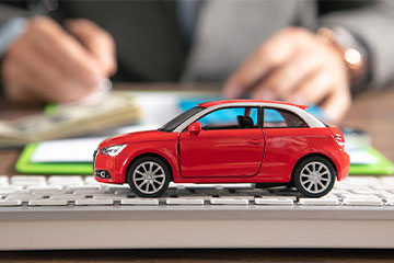 a red toy car sitting on a desk